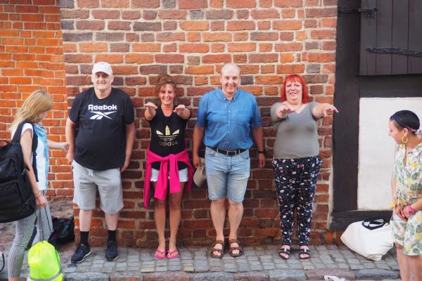 Mieszkańcy wraz z pracownikami domu w Toruniu pod krzywą wieżą.