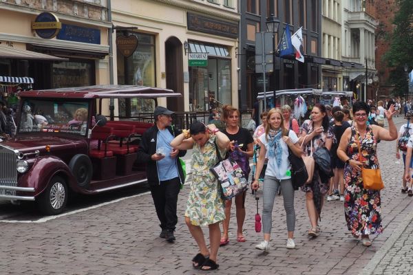 Mieszkańcy wraz z pracownikami domu w Toruniu spacerują alejkami.