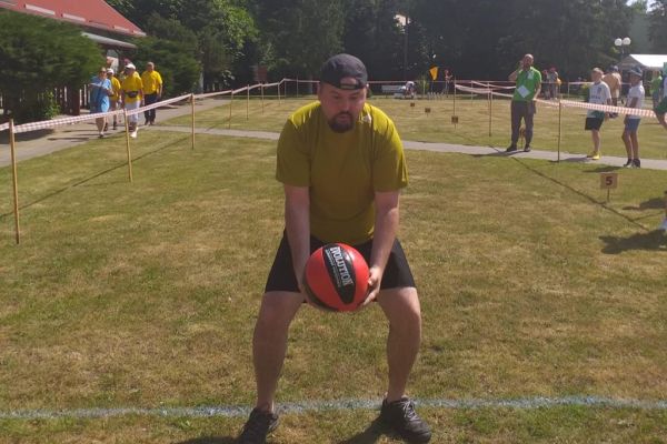 Mieszkańcy rzucaja piłką na olimpiadzie sportowej w DPS w Damaszce wśród innych uczestników zawodów sportowych.