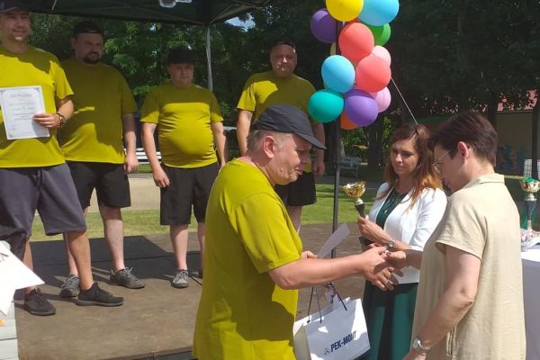 Mieszkańcy odbieraja nagrodę na olimpiadzie sportowej w DPS w Damaszce wśród innych uczestników zawodów sportowych.