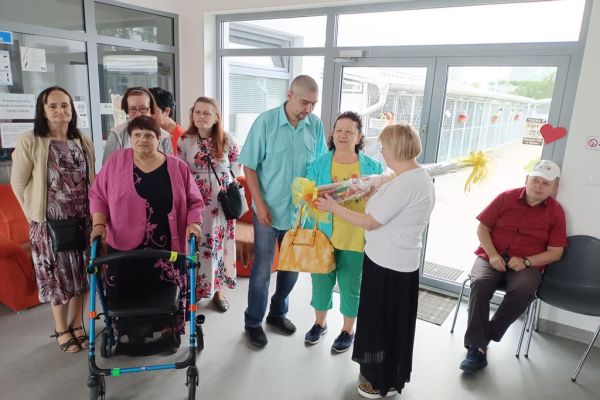 Mieszkańcy wraz z uczestnikami UTW z Redzikowa wręczaja prezent pani ze schroniska dla zwierząt.