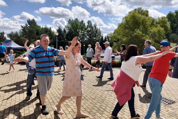 Mieszkańcy domu wraz z grupą wsparcia z gminy słupsk tańcza na pikniku.