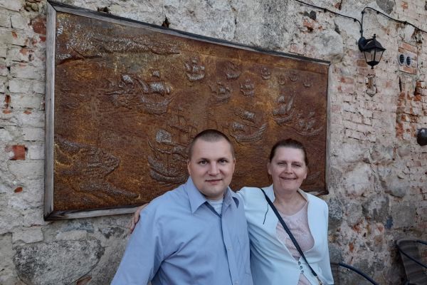 Dwójka mieszkańców przy wytłaczanym metalowym obrazie w starej gorzelni.