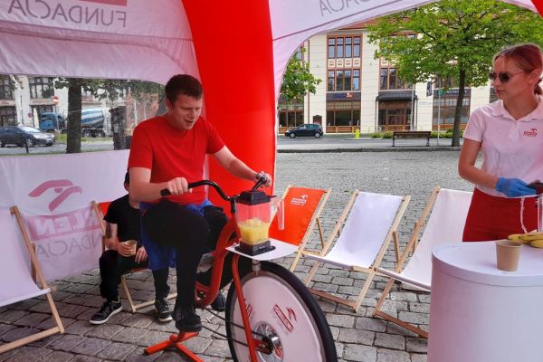 Mieszkaniec pedałuje specjalnym rowerem do wyciskania soku.