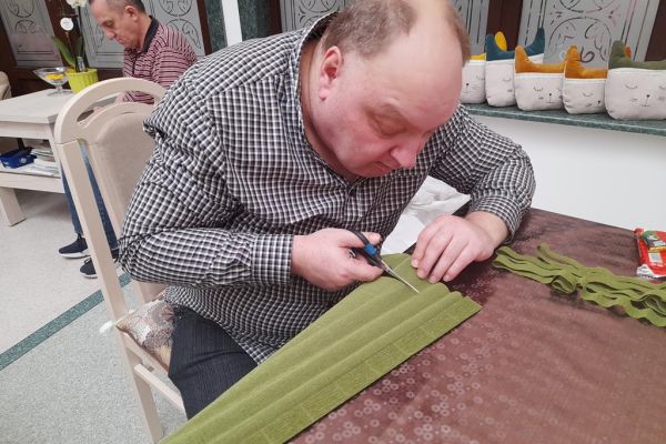 Mieszkaniec wycina bibułę.