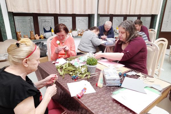 Mieszkanki wycinaja kwiaty z bibuły.