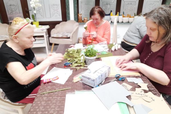 Mieszkanki wycinaja kwiaty z bibuły.