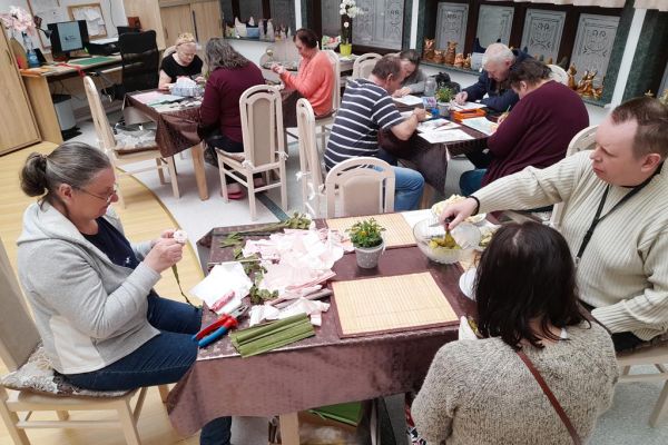 Mieszkańcy na pierwszym planie obieraja gruszki a na dalszym rysują i wycinaja.