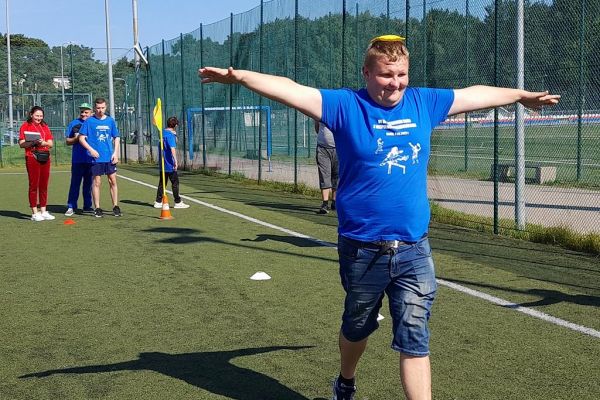 Uczestnicy spartakiady biegna z woreczkiem na głowie.