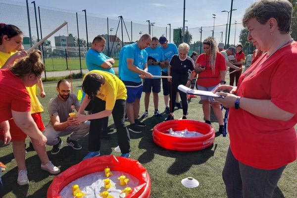 Uczestnicy spartakiady łowią drewniane rybki.