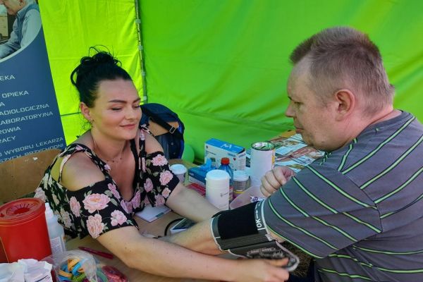 Mieszkaniec podczas pikniku w Korzybiu mierzy ciśnienie krwi.