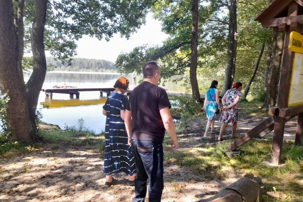 Mieszkańcy spacerują przy jeziorze.