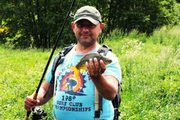 Mieszkaniec z rybą złowioną.