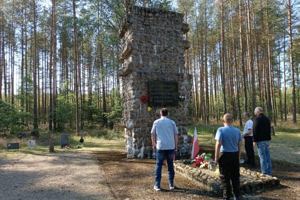 Mieszkańcy w lesie przy krzyżach.