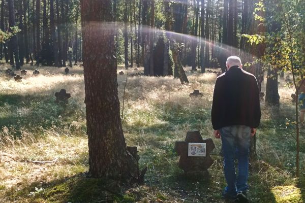 Mieszkaniec w lesie przy krzyżu.