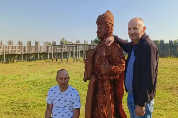 Mieszkaniec przy drewnianej figurze drewnianej.