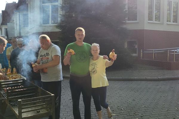 Mieszkańcy stoja przy grillu.