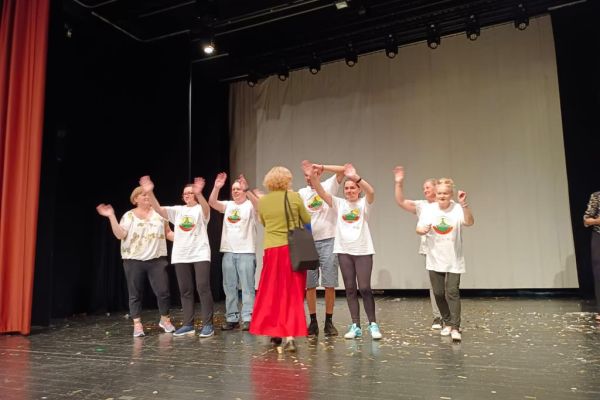 Mieszkańcy odbierają nagrodę na scenie.