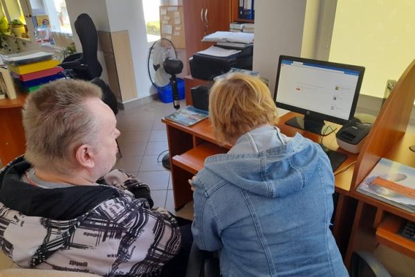 Mieszkaniec z terapeutką przy komputerze.