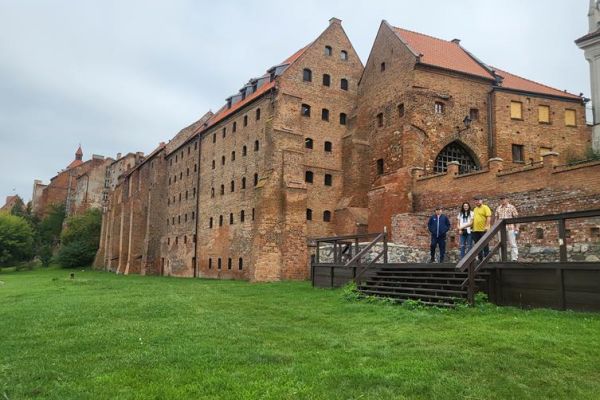 Czworo mieszkańców zwiedza stare miasto Grudziądz.