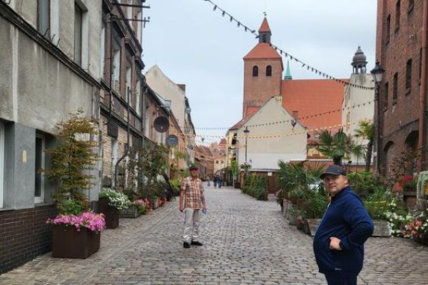 Czworo mieszkańców zwiedza stare miasto Grudziądz.
