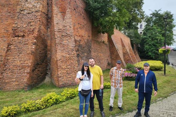 Czworo mieszkańców zwiedza stare miasto Grudziądz.