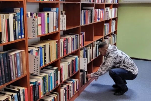 Mieszkaniec szuka książki w bibliotece.