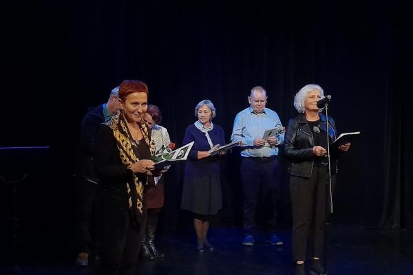 Mieszkaniec na scenie odbiera nagrodę.