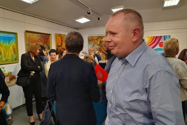 Mieszkaniec ogląda obrazy na wystawie.