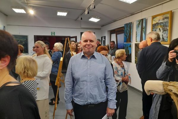 Mieszkaniec ogląda obrazy na wystawie.