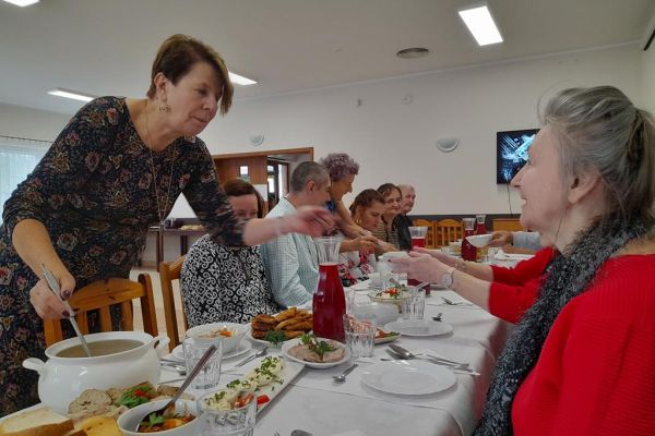 Mieszkańcy i pani Sołtys przy stole.