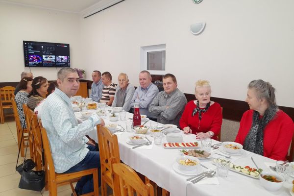 Meszkańcy przy stole w świetlicy.