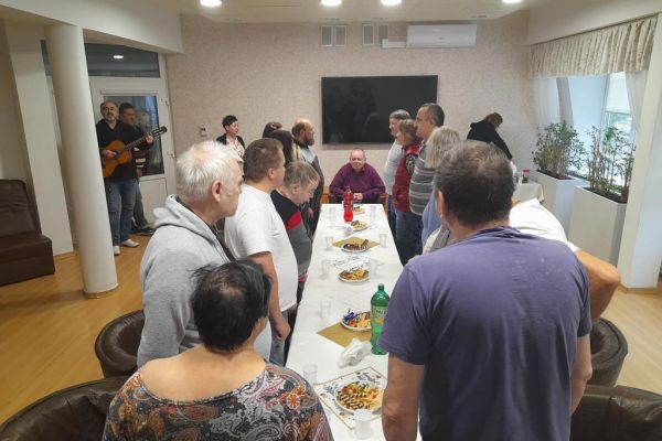 Mieszkańcy na stojąco śpiewają sto lat jubilatowi.