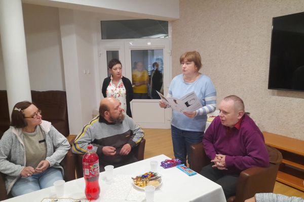 Terapeutka ogłasza gościom jubilata o wygranej nagrodzie pana Ernesta.