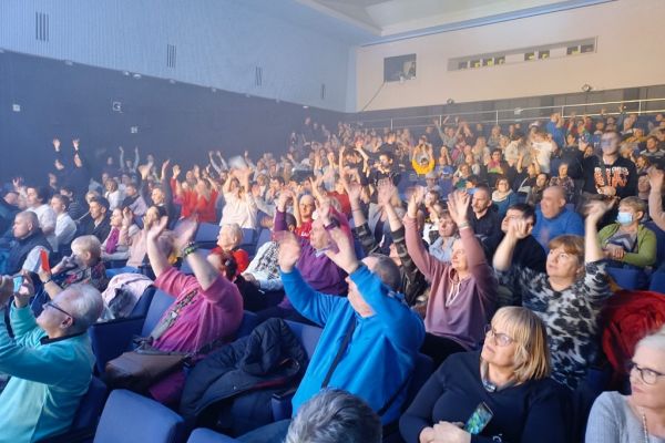 Uczestnicy festiwalu w teatrze  bawia sie przy dźwiękach zespołu.