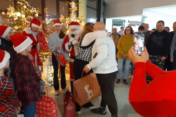 Dariusz Kloskowski i jego Śnieżynki rozdają Mieszkańcom prezenty na holu.