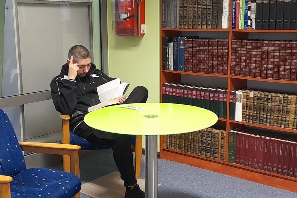 Dwoje mieszkaniec czyta przy stoliku w czytelni.