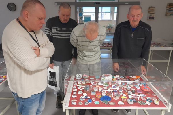 mieszkańcy oglądaja wystawę kamyków.
