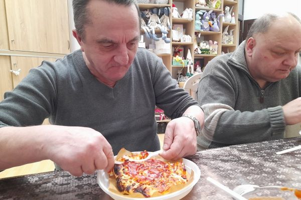 Mieszkaniec je upieczoną pizze.