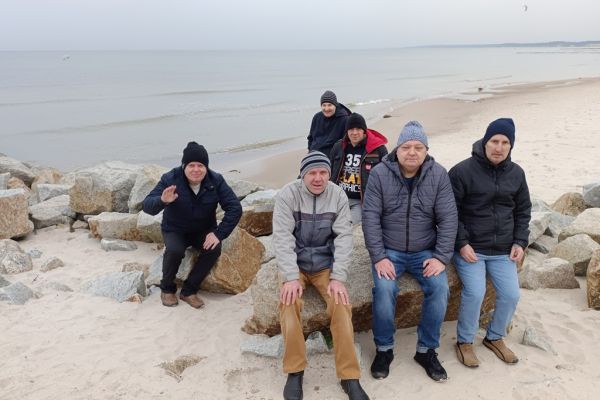 Mieszkańcy siedzą nad morzem.