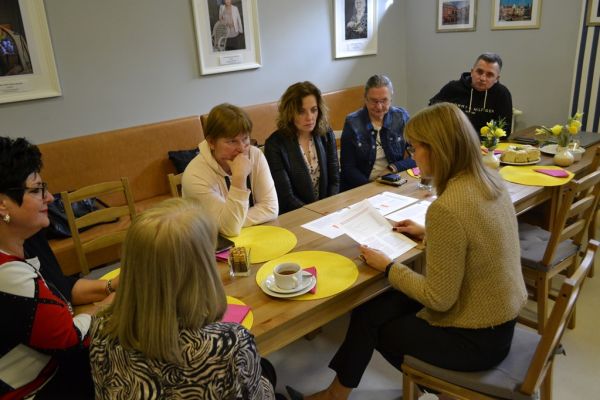 Pracownicy siedza na szkoleniu , prowadza rozmowy.