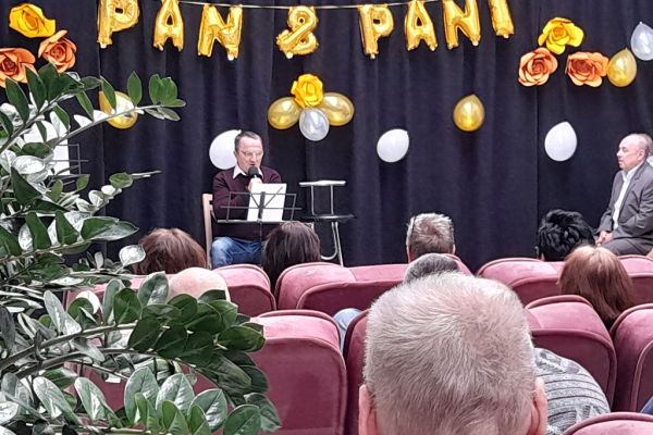 Mieszkaniec śpiewa na holu domu podczas uroczystości.