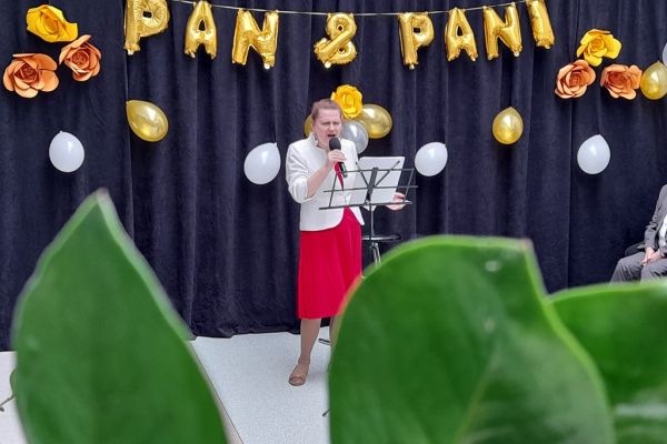 Mieszkanka śpiewa na holu domu podczas uroczystości.