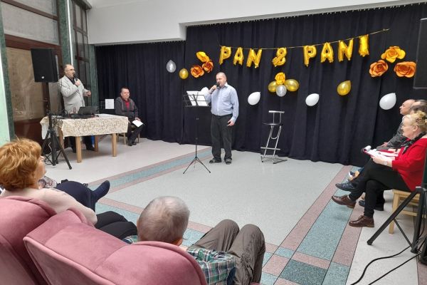 Mieszkaniec śpiewa na holu domu podczas uroczystości.