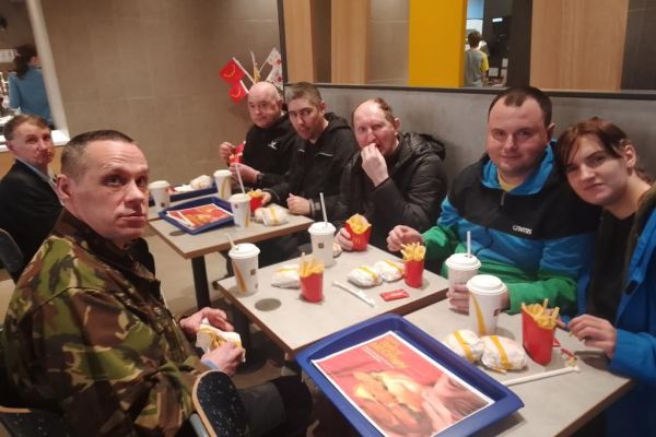 Mieszkańcy w restauracji spożywaja posiłek siedząc przy stolikach.