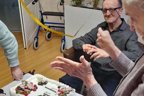 Solenizant siedzi i się uśmiecha.