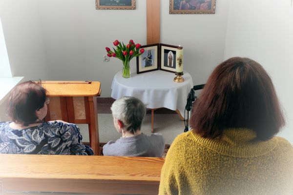 Mieszkańcy w małej kapliczce modlą sie do obrazków świętych.