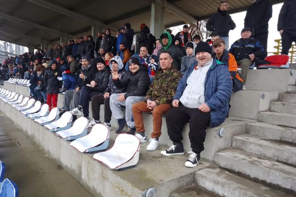 Mieszkańcy siedzą na widowni na meczu piłki nożnej.