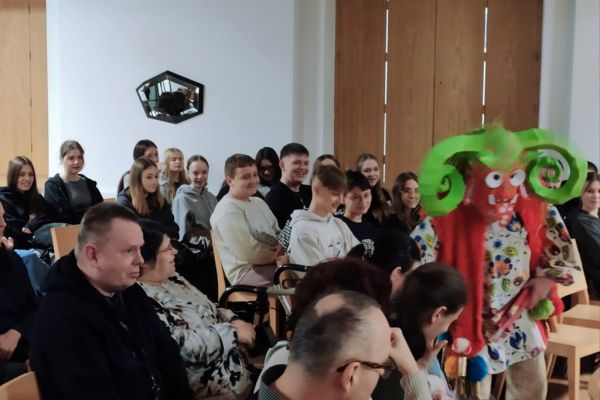 Mieszkańcy wraz z innymi uczestnikami oglądają spektakl.