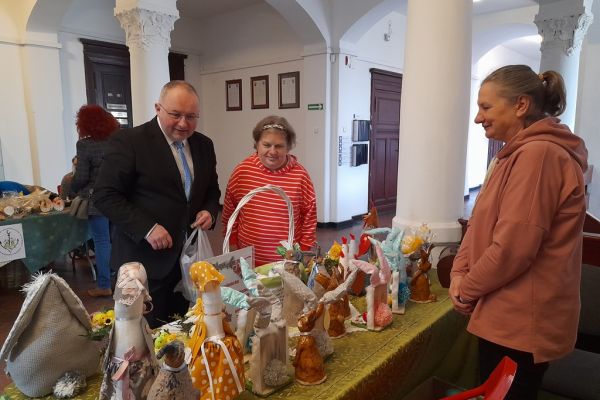 Prace mieszkańców wykonane na terapii zajęciowej na wystawie w Starostwie Powiatowym w Słupsku. Pan Wicestarosta ogląda wystawę.